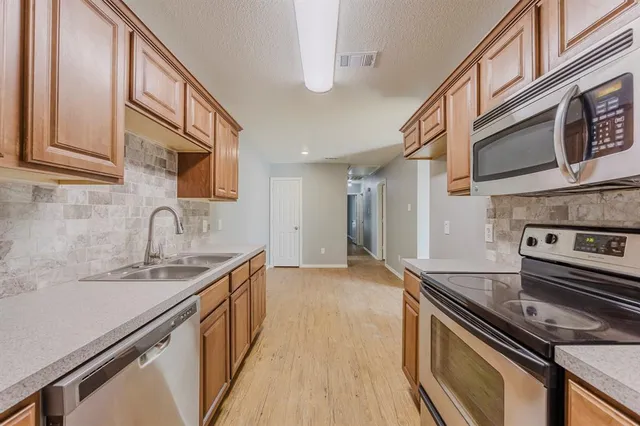 a kitchen with stainless steel appliances granite countertop a sink and a stove