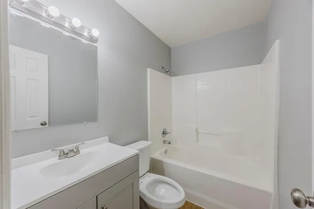 a bathroom with a sink toilet vanity and bathtub