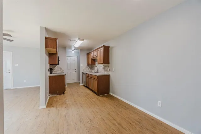 a view of a kitchen with wooden floor and electronic appliances