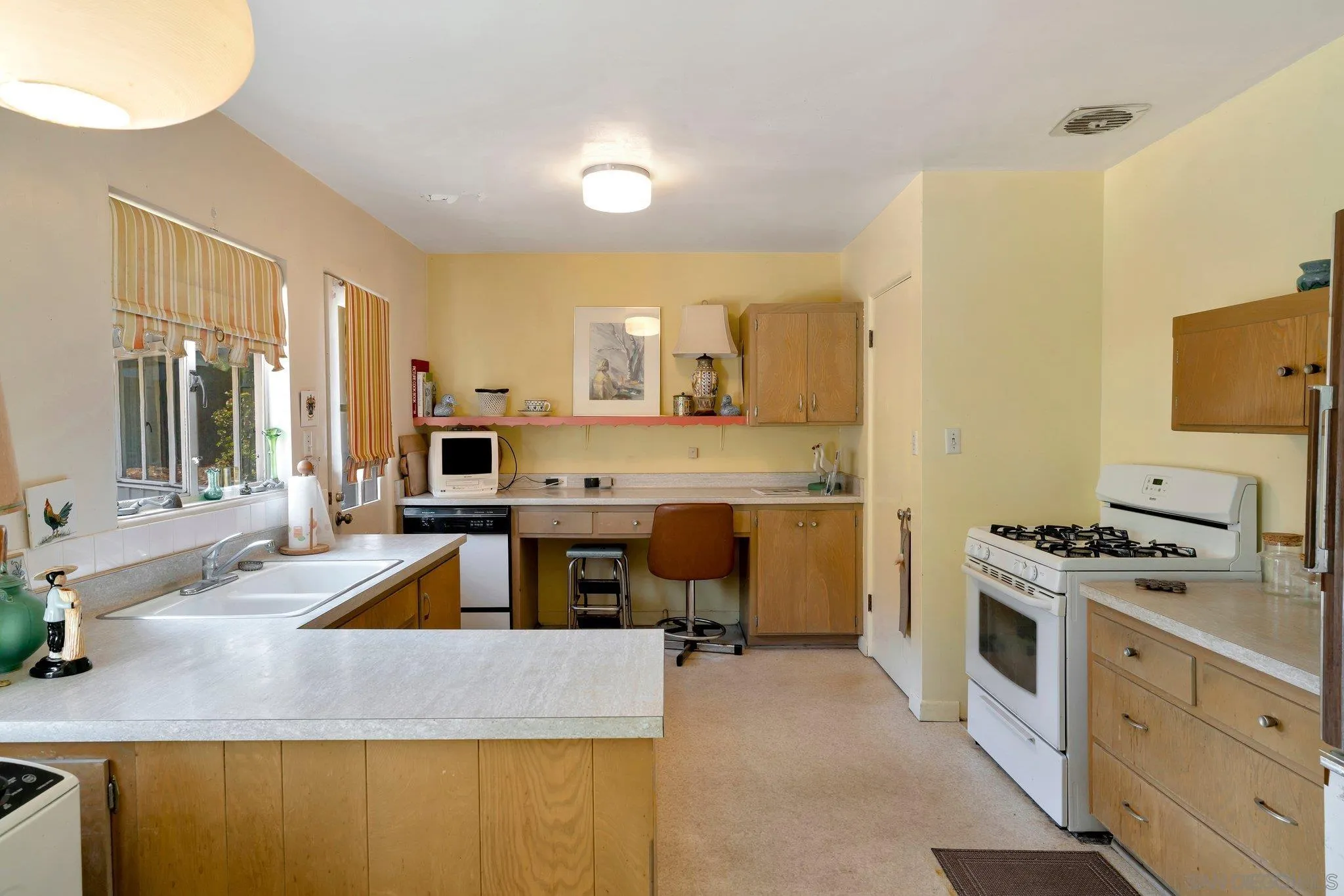 1351 Rhoda Drive La Jolla, CA 92037 - Photo 14 of 20 a kitchen with stainless steel appliances granite countertop a sink stove and refrigerator