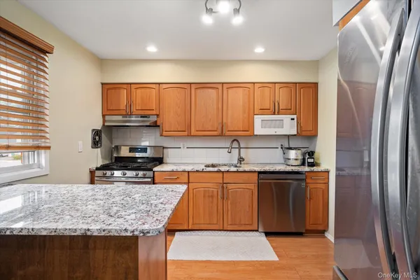 a kitchen with stainless steel appliances granite countertop a sink stove and refrigerator