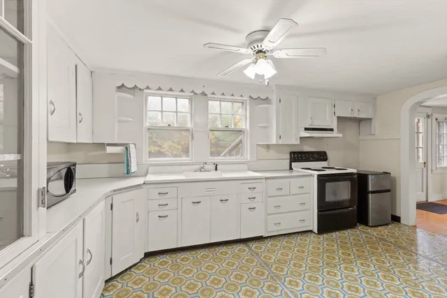 a kitchen with white cabinets and appliances