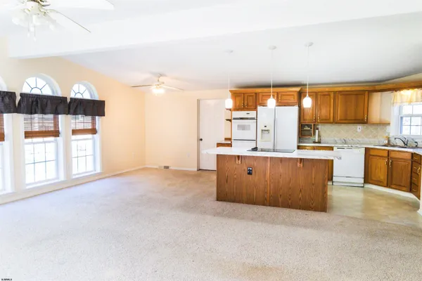 a large kitchen with kitchen island a window a sink and a counter in it