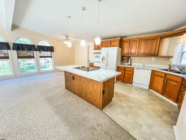 a large kitchen with stainless steel appliances granite countertop a stove top oven a sink dishwasher and cabinets with wooden floor
