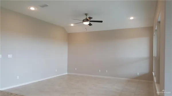an empty room with a ceiling fan and window