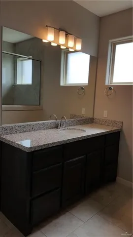 a bathroom with granite countertop a sink and a mirror