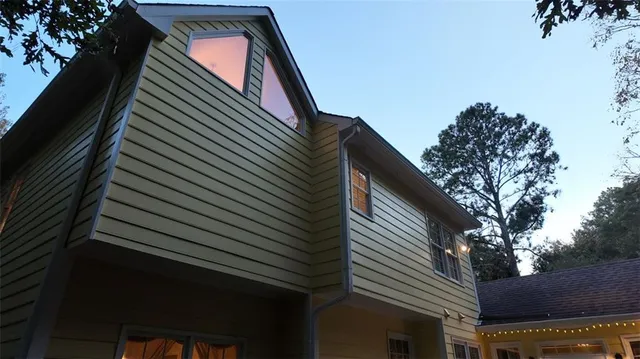 an aerial view of a house with yard and trees