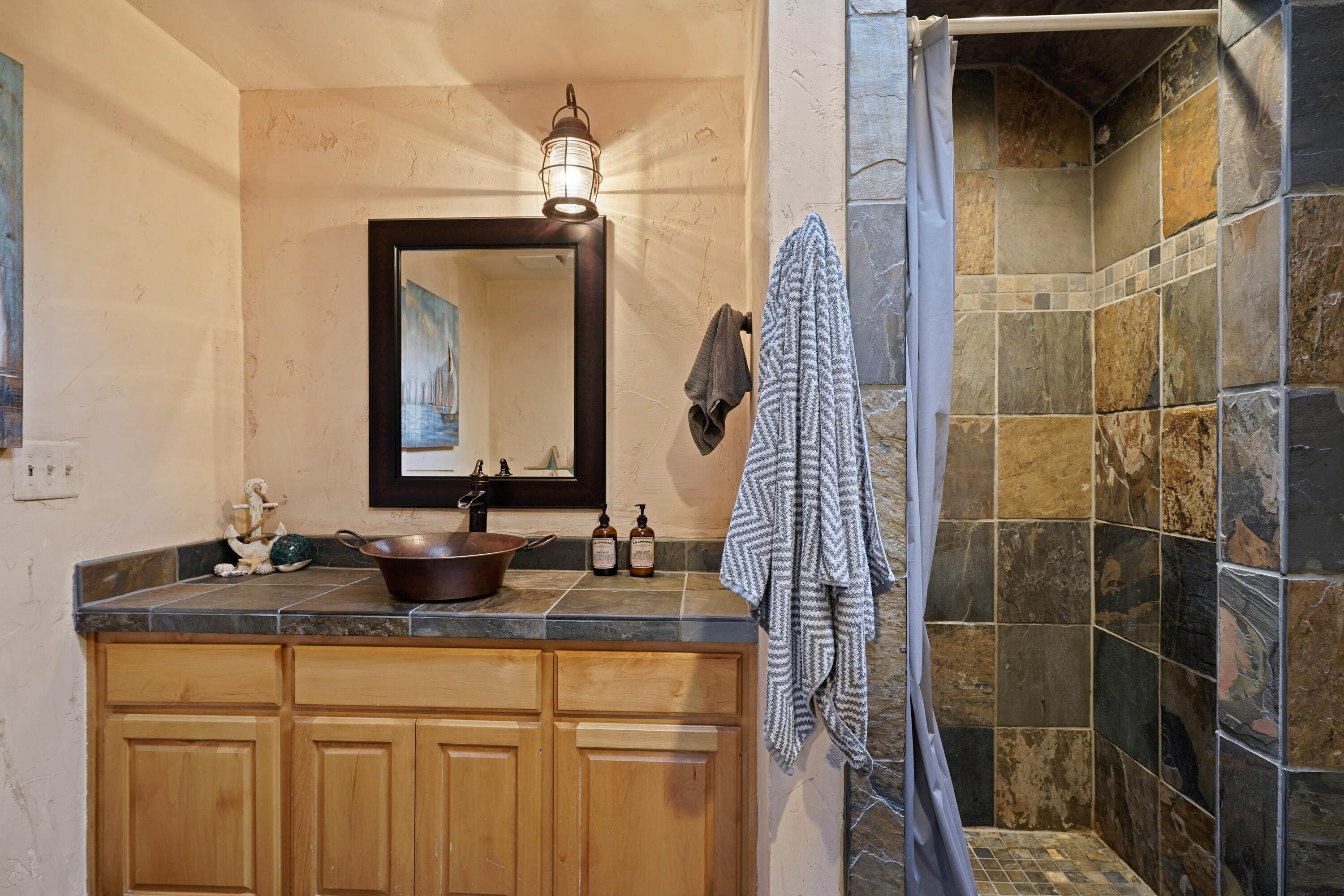 63520 Cricketwood Road Bend, OR 97701 - Photo 45 of 84 a bathroom with a granite countertop shower a sink and a mirror