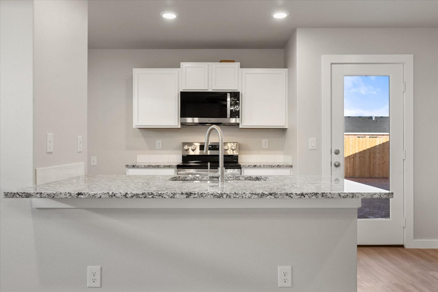 5516 Princeton Street Lubbock, TX 79416 - Photo 7 of 17 a kitchen with granite countertop a sink and a stove top oven