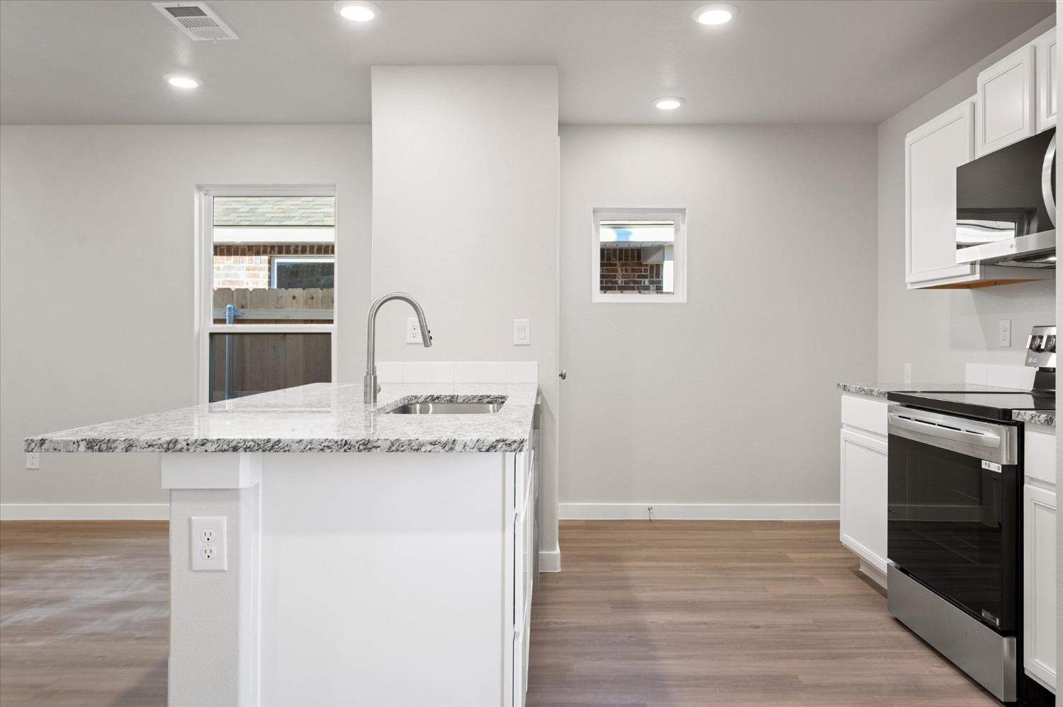 5516 Princeton Street Lubbock, TX 79416 - Photo 9 of 17 a kitchen with granite countertop a stove and a sink