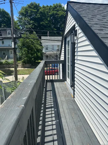 a balcony with wooden floor and outdoor seating