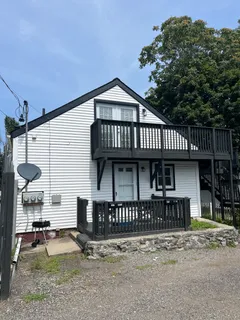 a view of a house with large windows and a small yard
