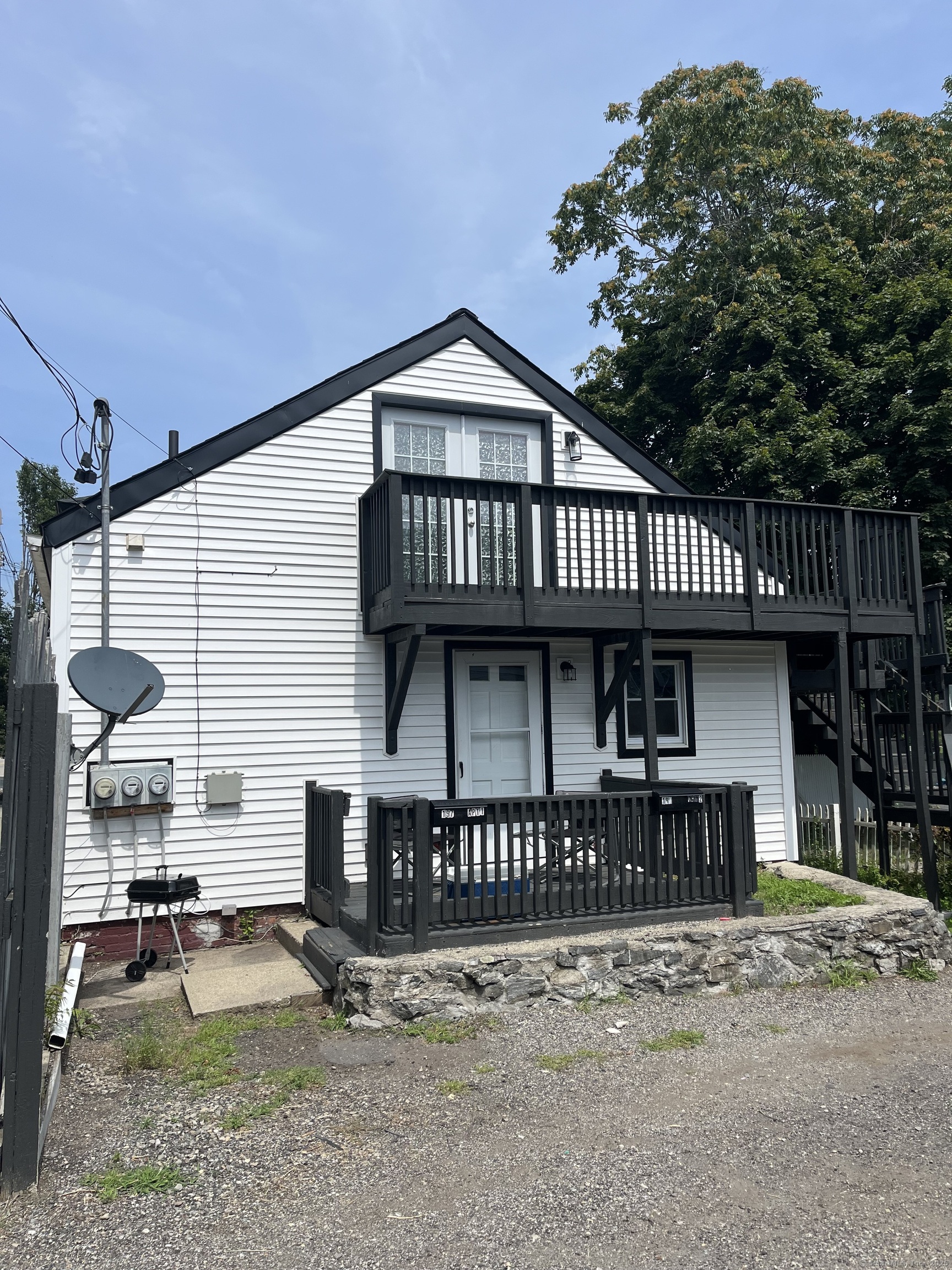 197 Central Avenue Norwich, CT 06360 - Photo 4 of 16 a view of a house with large windows and a small yard