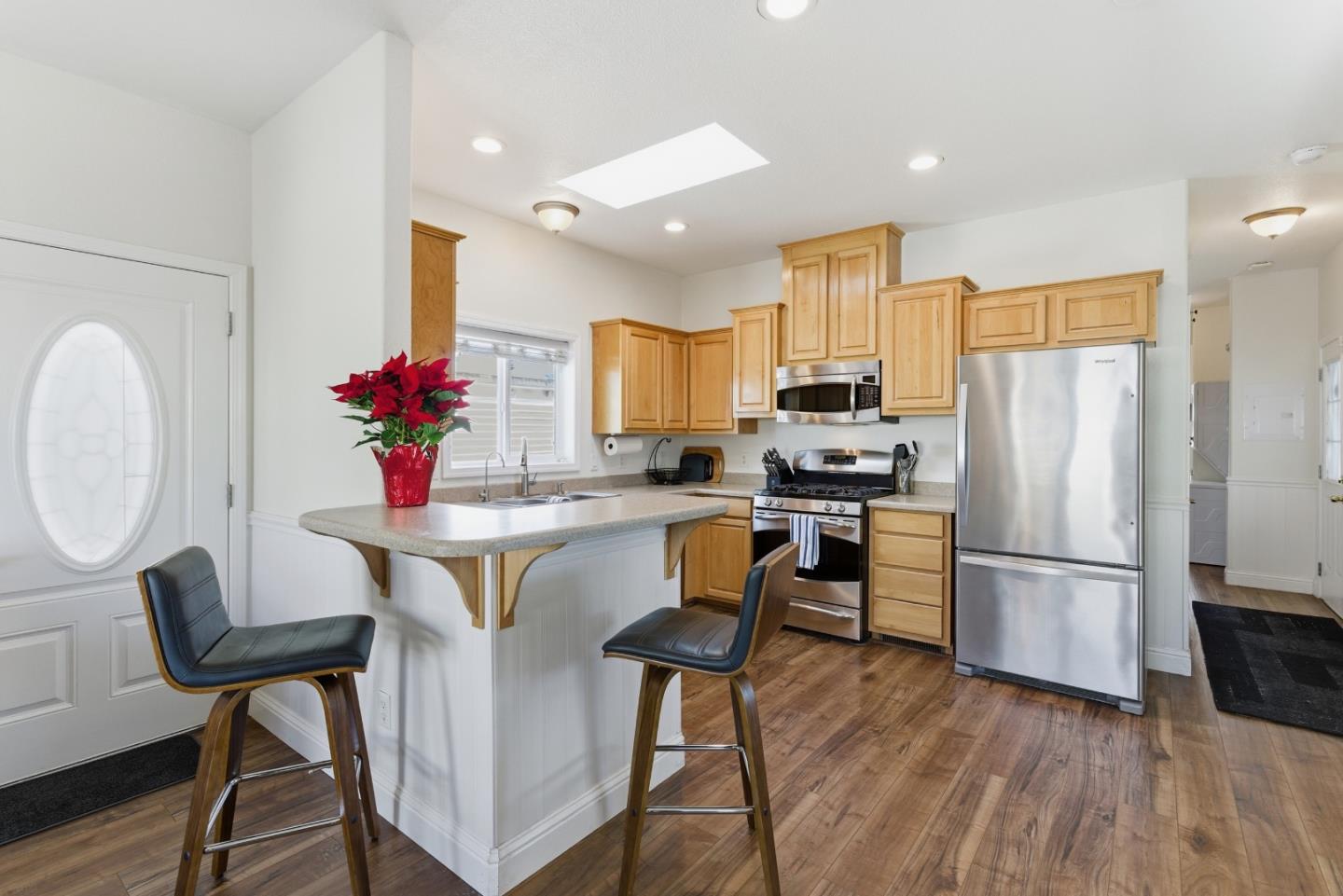 930 Rosedale Avenue, Unit 68 Capitola, CA 95010 - Photo 6 of 20 a kitchen with stainless steel appliances granite countertop a refrigerator a stove a sink dishwasher and a dining table with wooden floor