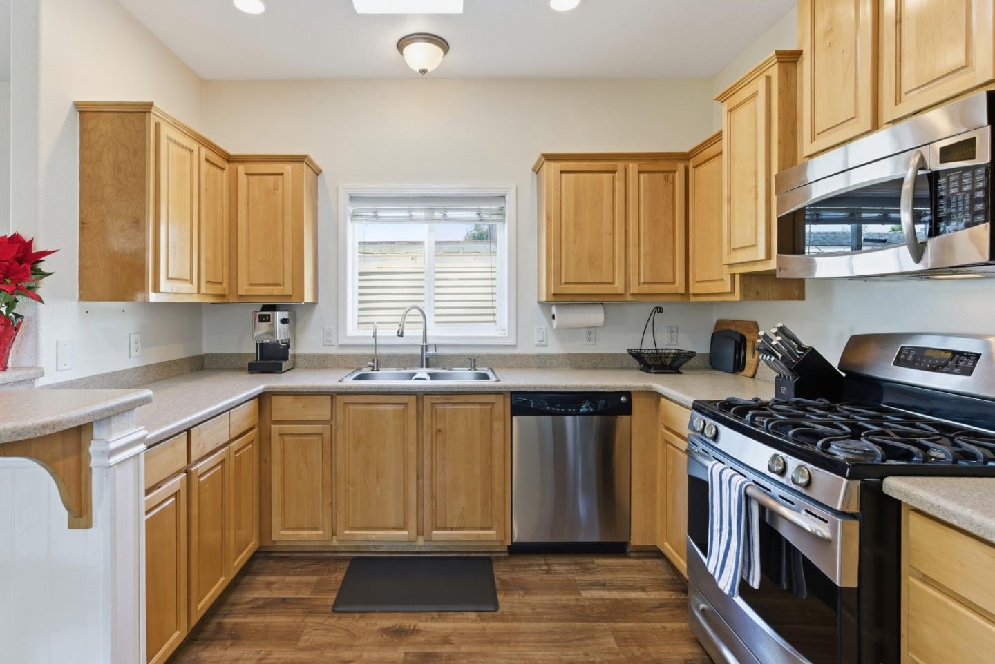 930 Rosedale Avenue, Unit 68 Capitola, CA 95010 - Photo 7 of 20 a kitchen with stainless steel appliances granite countertop a stove a sink dishwasher and a microwave oven with large wooden cabinets