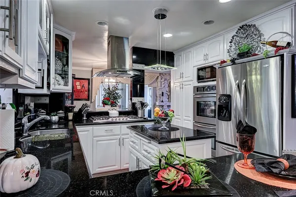 a kitchen with stainless steel appliances a sink a stove a refrigerator and cabinets