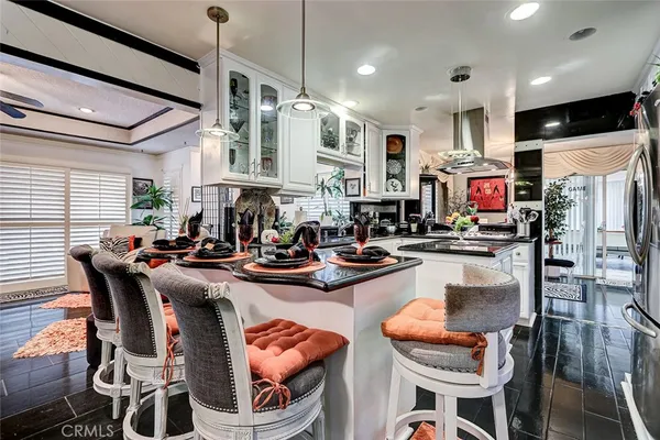 a kitchen with sink a stove and chairs