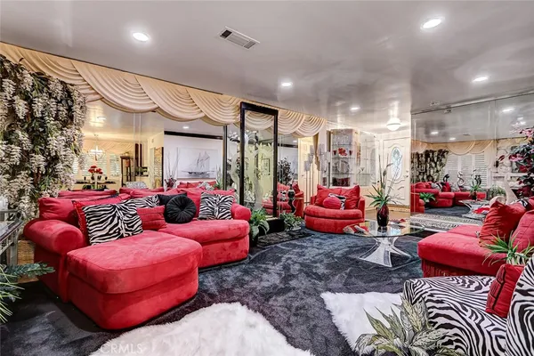a living room with furniture kitchen view and a chandelier