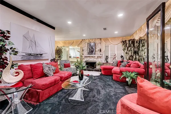 a living room with furniture a fireplace and a floor to ceiling window