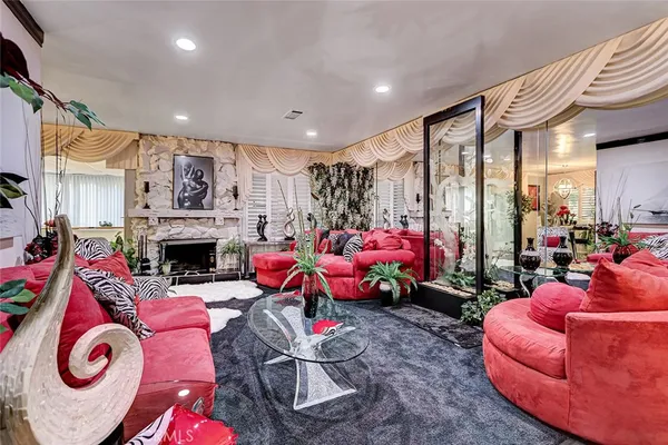 a living room with furniture a fireplace and a floor to ceiling window