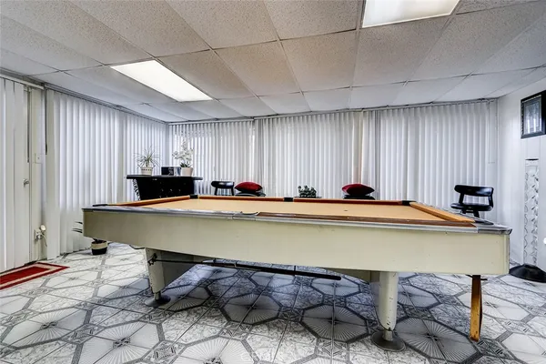 a room with furniture pool table and chairs