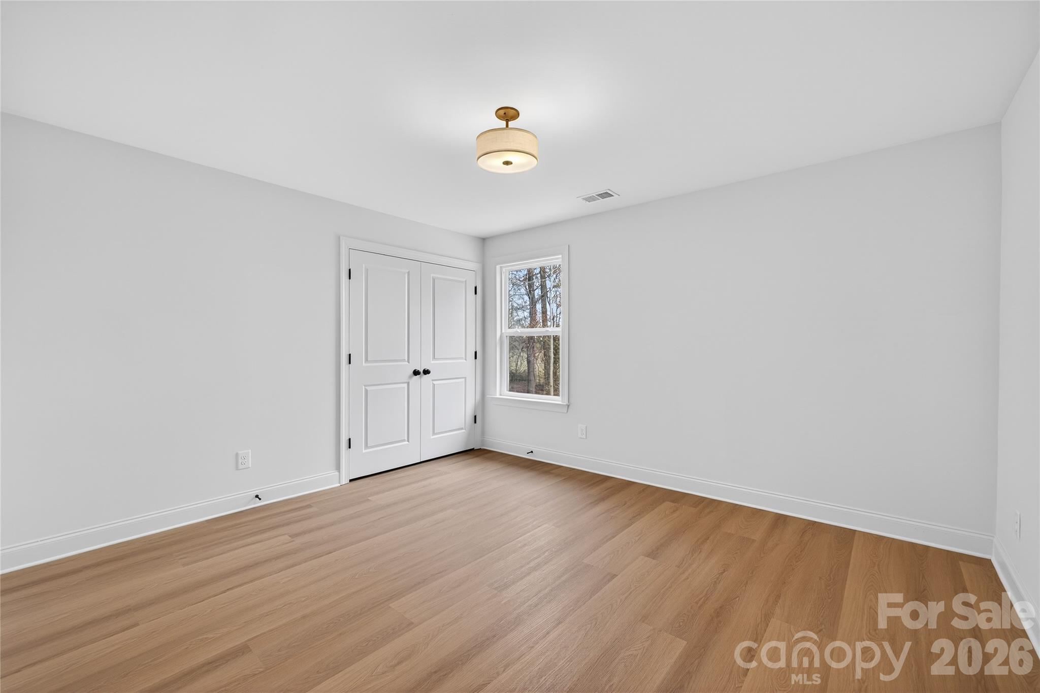 13103 Blacksmith Court Matthews, NC 28105 - Photo 26 of 32 a view of an empty room with wooden floor and a window