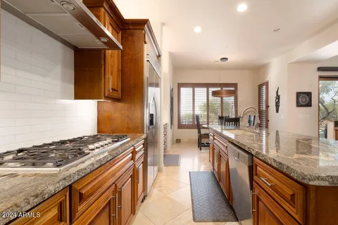a kitchen with stainless steel appliances granite countertop sink stove top oven and cabinets
