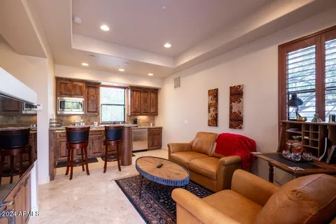 a living room with furniture a flat screen tv and a floor to ceiling window