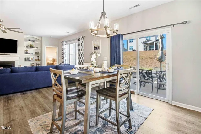 a dining room with furniture a chandelier and wooden floor