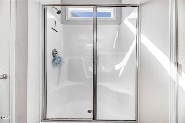 a spacious bathroom with a granite countertop sink a mirror and shower view