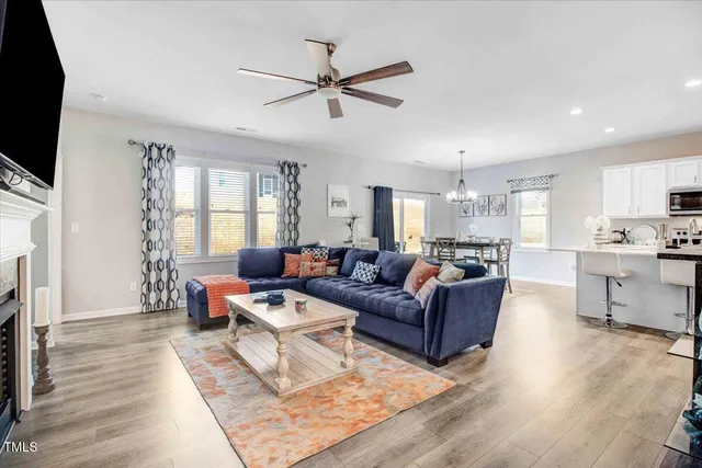 a living room with furniture a flat screen tv and a fireplace