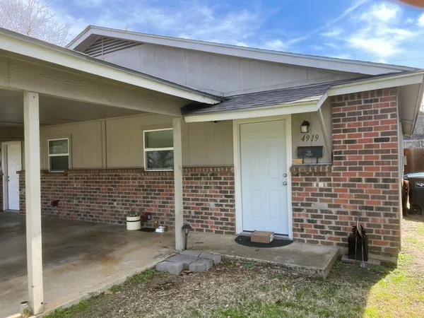 a view of house with door space and wooden fence