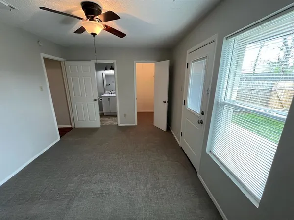 a view of a livingroom with a ceiling fan and window