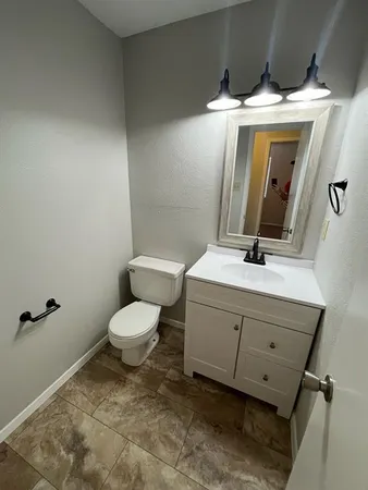 a bathroom with a toilet sink and mirror