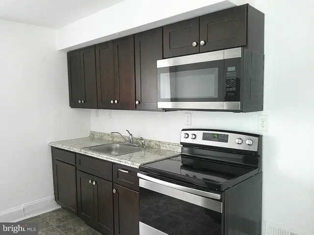 a kitchen with a sink stove and microwave