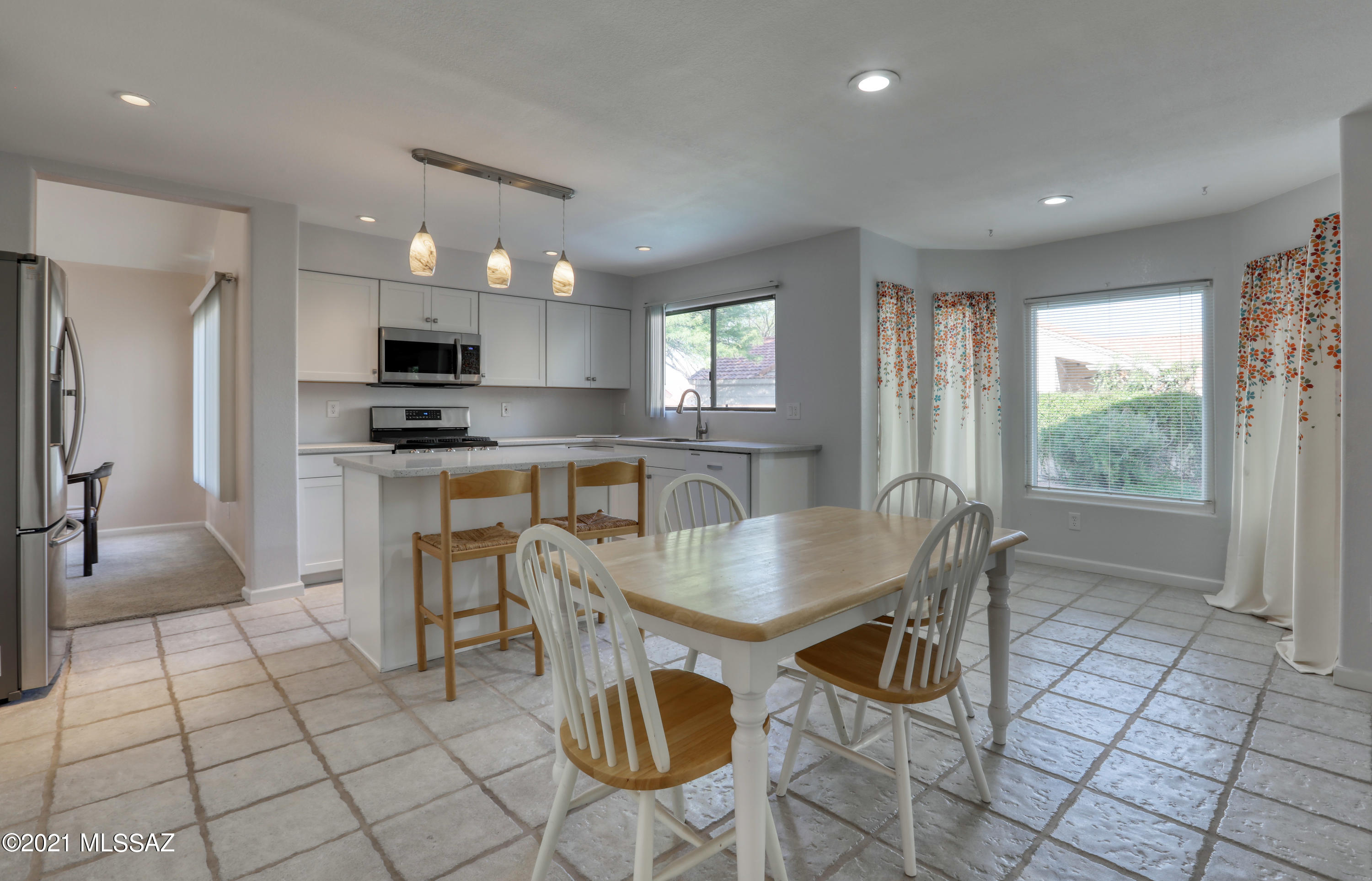12560 North Wayfarer Way Oro Valley, AZ 85755 - Photo 11 of 43 a kitchen with stainless steel appliances kitchen island granite countertop a sink a stove a table and chairs