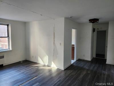 485 Bronx River Road, Unit B15 Yonkers, NY 10704 - Photo 3 of 8 an empty room with wooden floor and a window