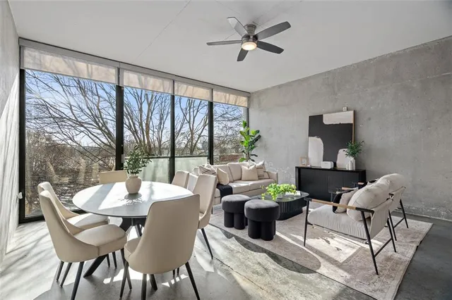 a dining room with furniture a large window and a chandelier