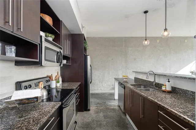 a kitchen with stainless steel appliances granite countertop a refrigerator and a stove