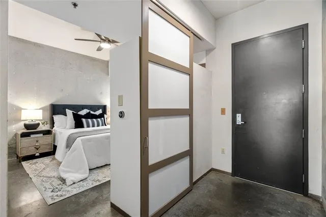 a bedroom with a large bed and a potted plant