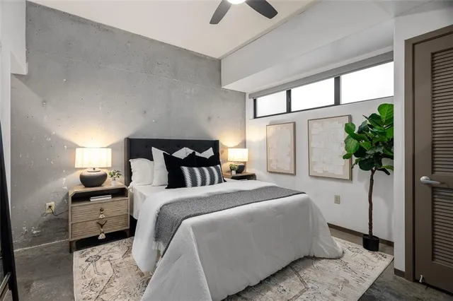 a bedroom with a bed potted plant with the mirror