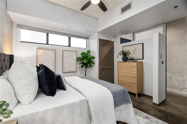 a bedroom with a bed and a painting on the wall