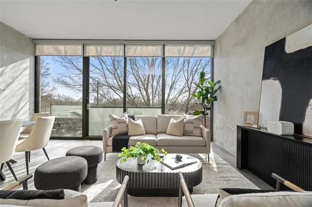 a living room with furniture fireplace and a large window
