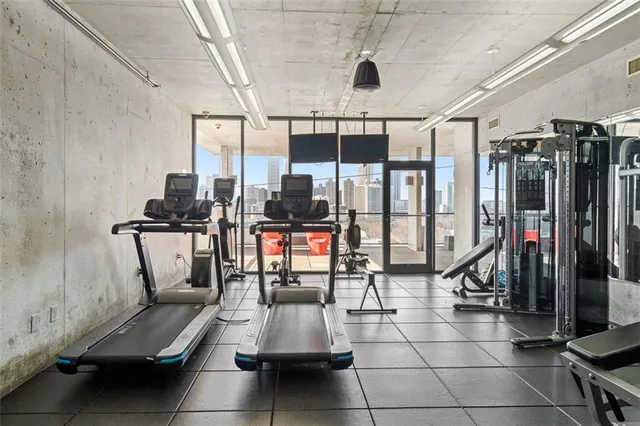 a living room with furniture a flat screen tv and floor to ceiling windows