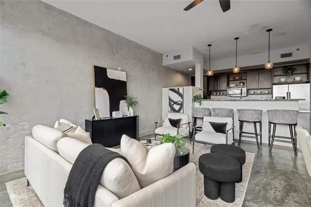 a kitchen with stainless steel appliances granite countertop a stove a refrigerator a kitchen island a sink and a table