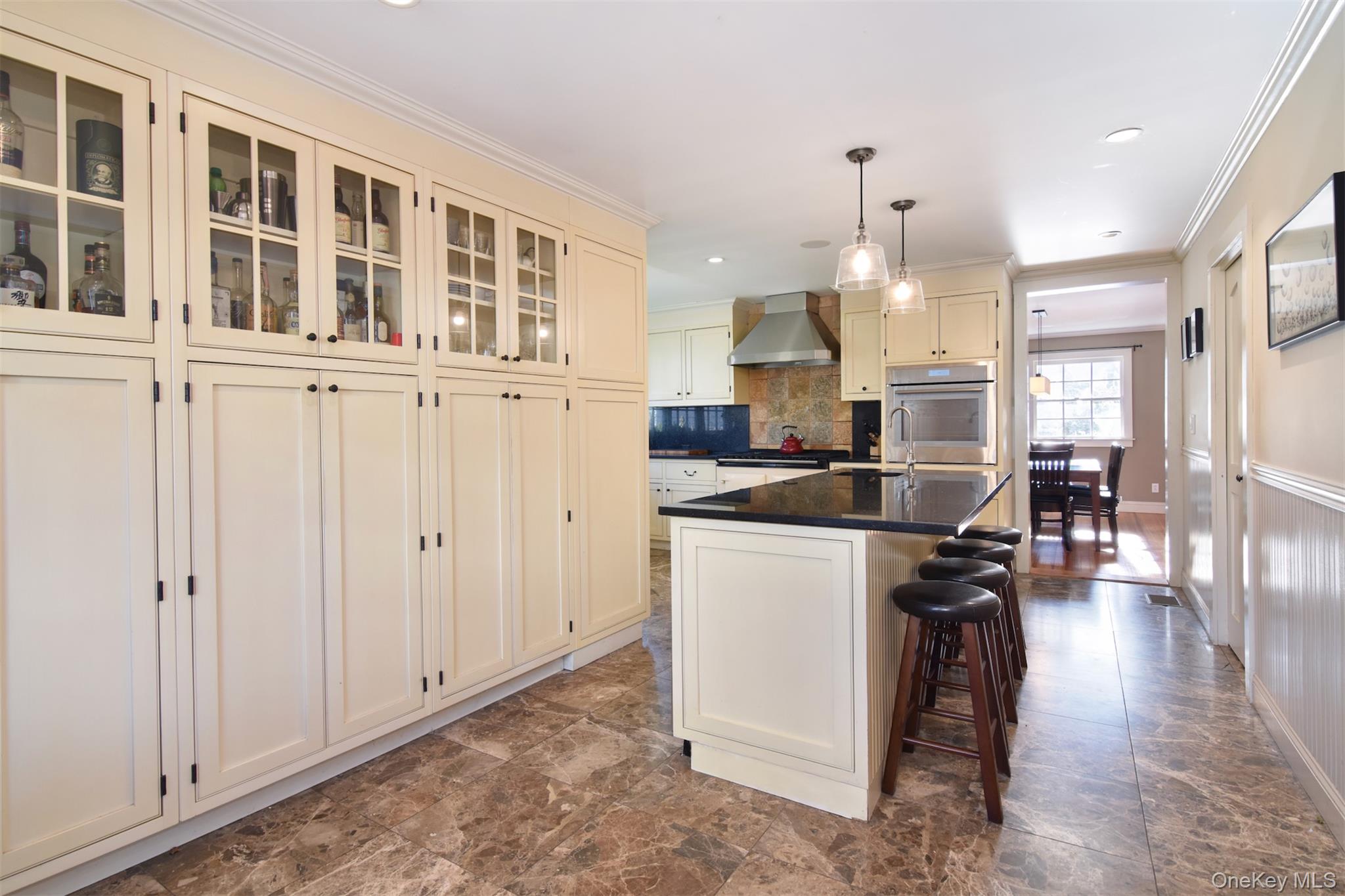 414 Pelham Manor Road Pelham, NY 10803 - Photo 9 of 32 a kitchen with a sink dishwasher a dining table and chairs with wooden floor