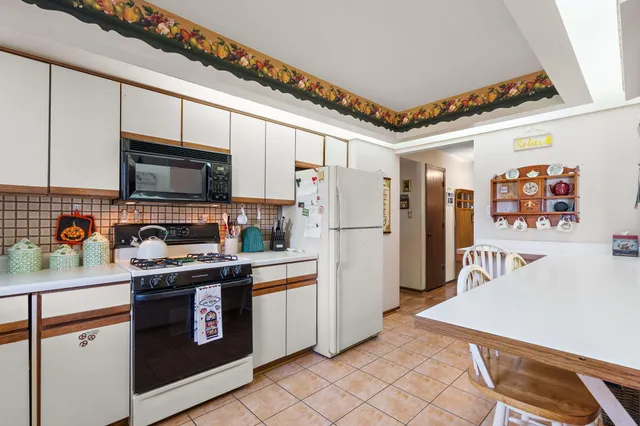 a kitchen with stainless steel appliances granite countertop a refrigerator a stove top oven a sink and dishwasher