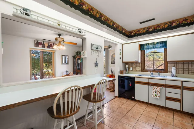 a large white kitchen with a large window
