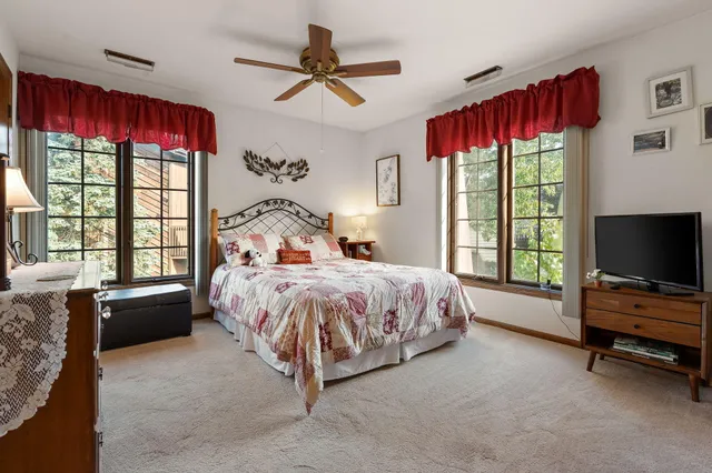 a spacious bedroom with a bed a window and a flat screen television