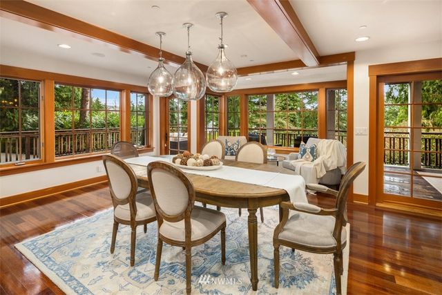 a view of a dining room with furniture large windows and wooden floor
